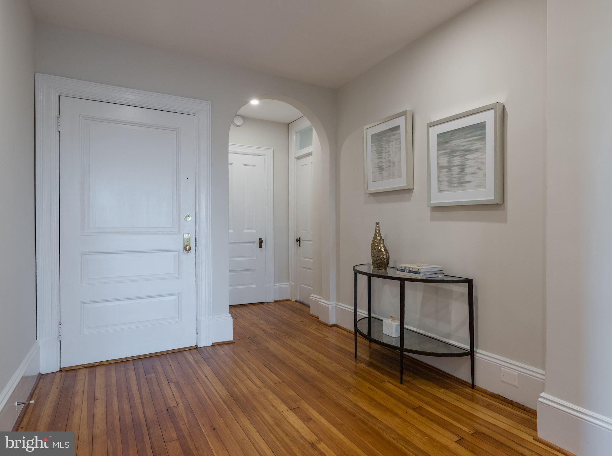 2853 Ontario Road Northwest, Unit 505 Washington, DC 20009 - Photo 5 of 29 a view of a hallway with wooden floor and staircase