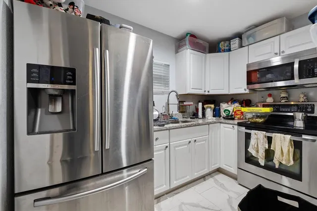 a kitchen with stainless steel appliances a refrigerator sink and microwave