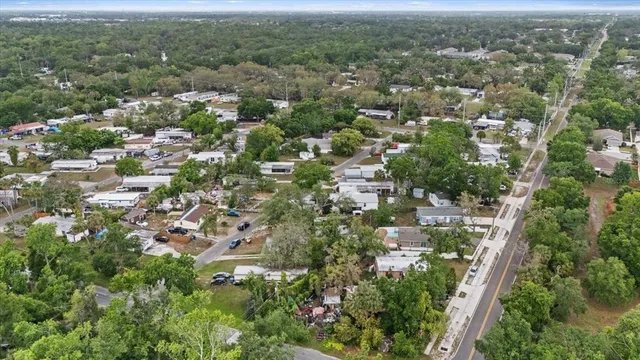 an aerial view of residential houses with outdoor space and trees