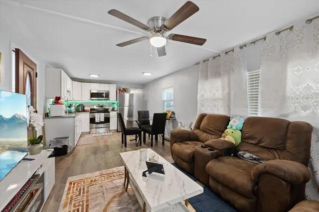 a living room with furniture kitchen view and a chandelier