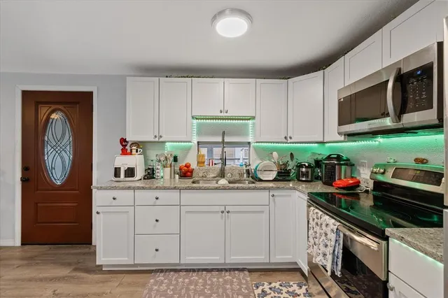 a kitchen with stainless steel appliances granite countertop a stove a sink and a microwave
