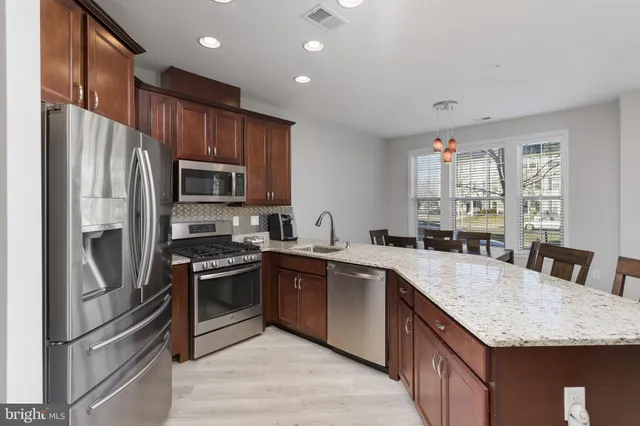 a open kitchen with stainless steel appliances granite countertop a stove and a sink