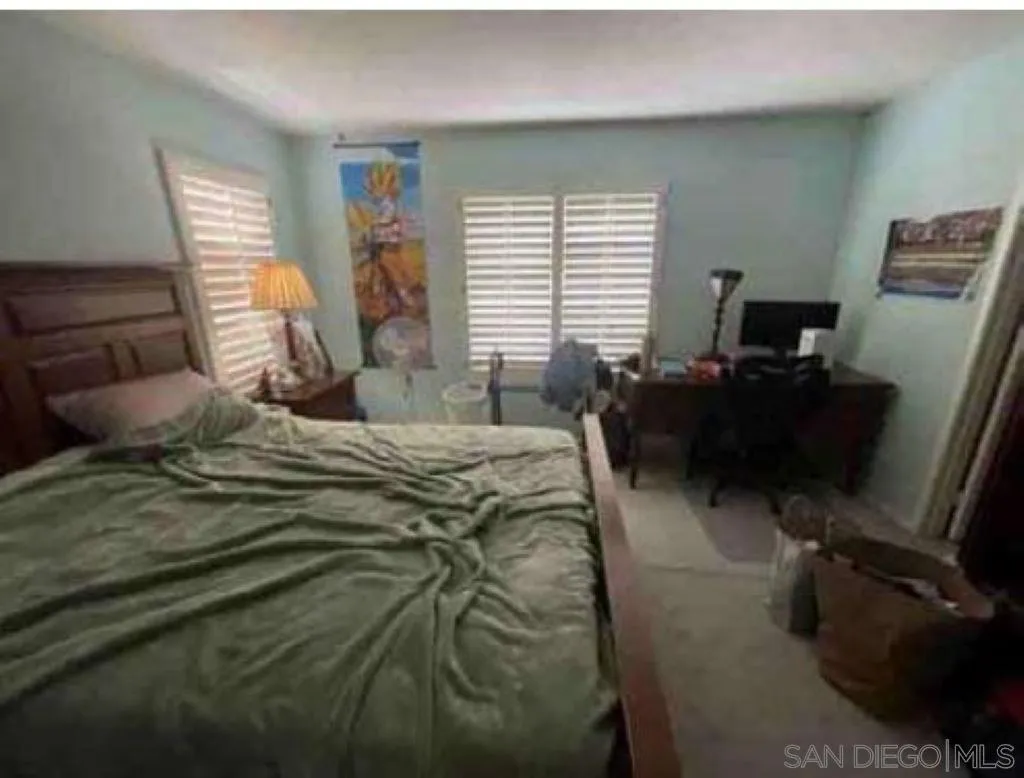 2552 Valley Waters Court Spring Valley, CA 91978 - Photo 6 of 16 a bedroom with a bed a computer on the desk and a wooden floor