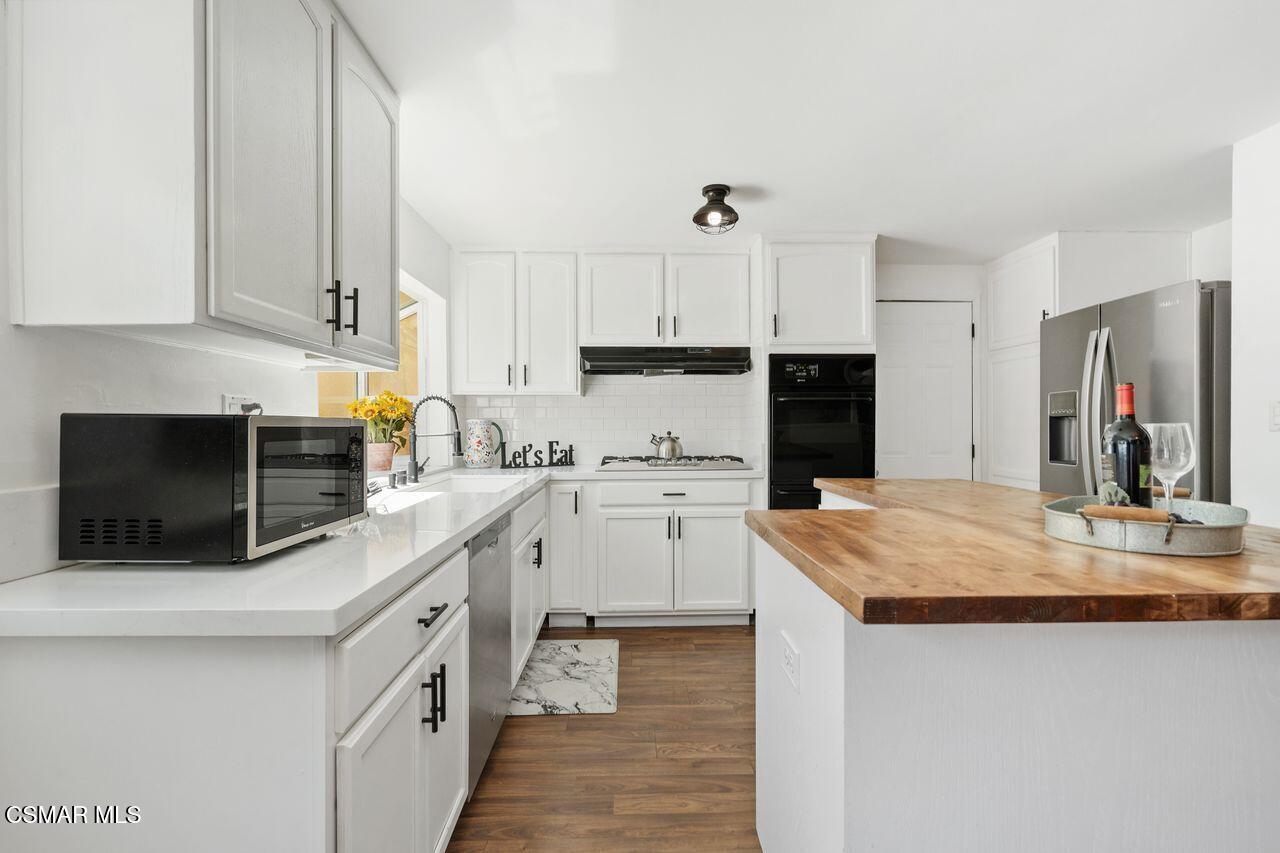 2142 Atwater Avenue Simi Valley, CA 93063 - Photo 15 of 36 a kitchen with granite countertop a sink a stove top oven and white cabinets