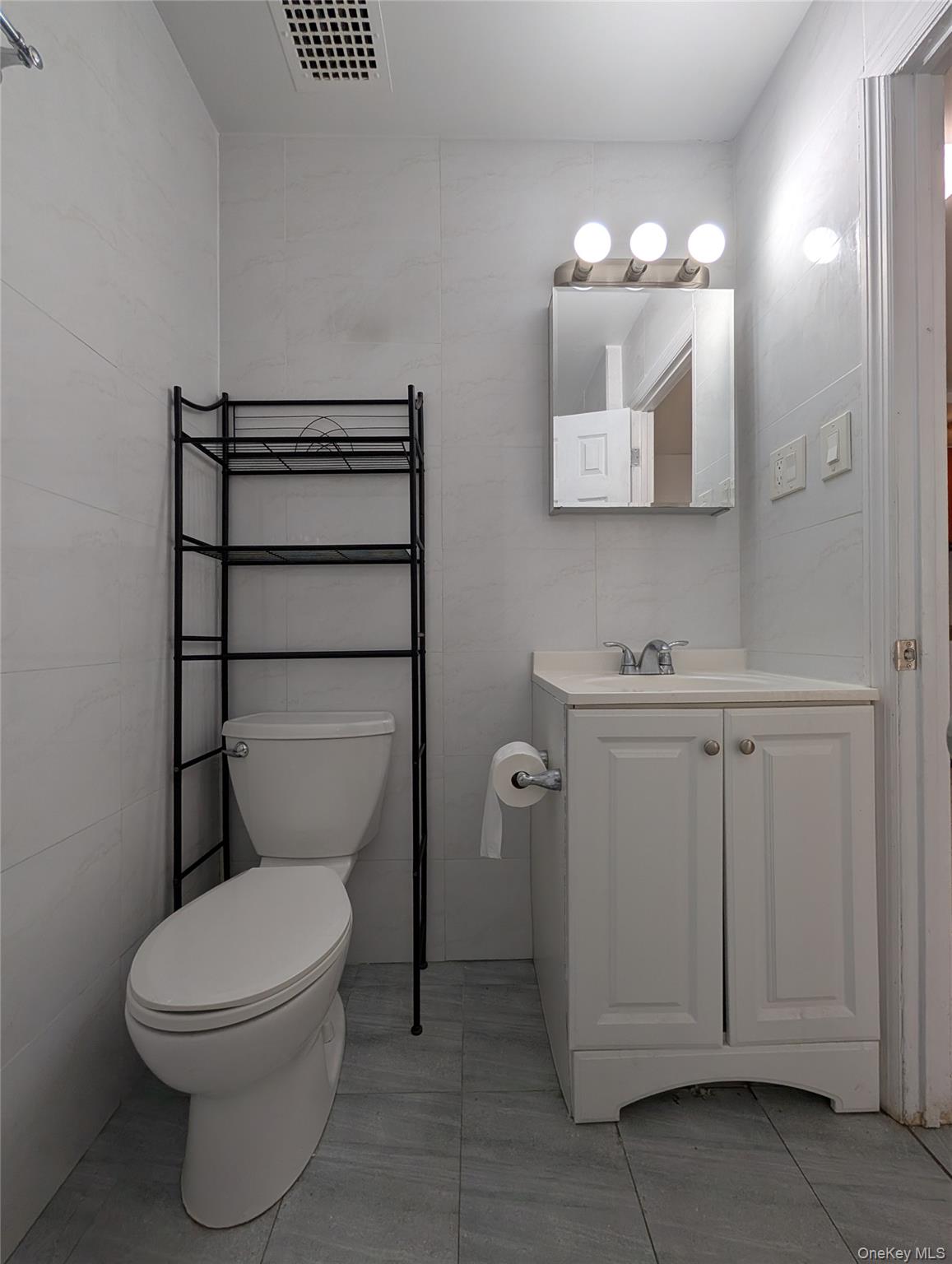 43-04 158th Street, Unit L4 Queens, NY 11358 - Photo 11 of 21 Bathroom with vanity and tile walls