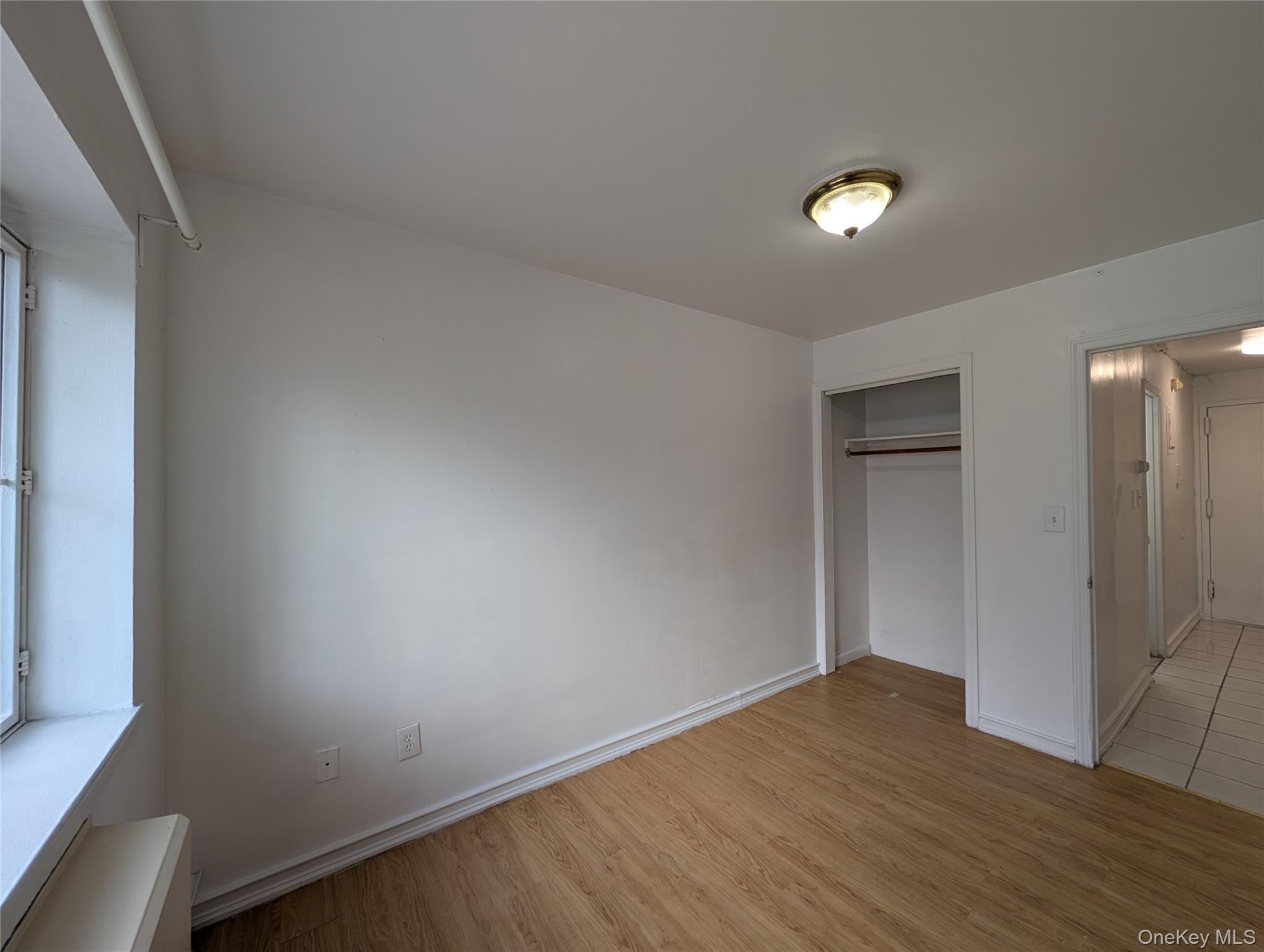 43-04 158th Street, Unit L4 Queens, NY 11358 - Photo 16 of 21 Unfurnished bedroom with light wood finished floors and a closet