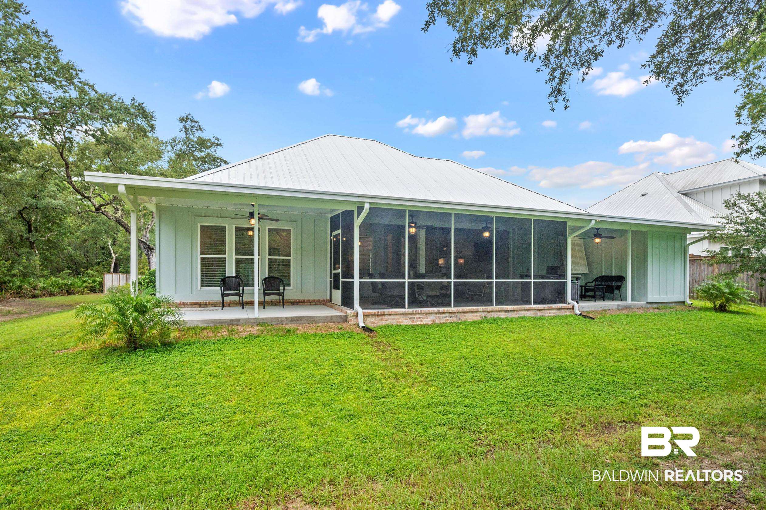4601 Surrey Lane Orange Beach, AL 36561 - Photo 35 of 43 Back of property featuring a patio area, a sunroom, a lawn, and ceiling fan