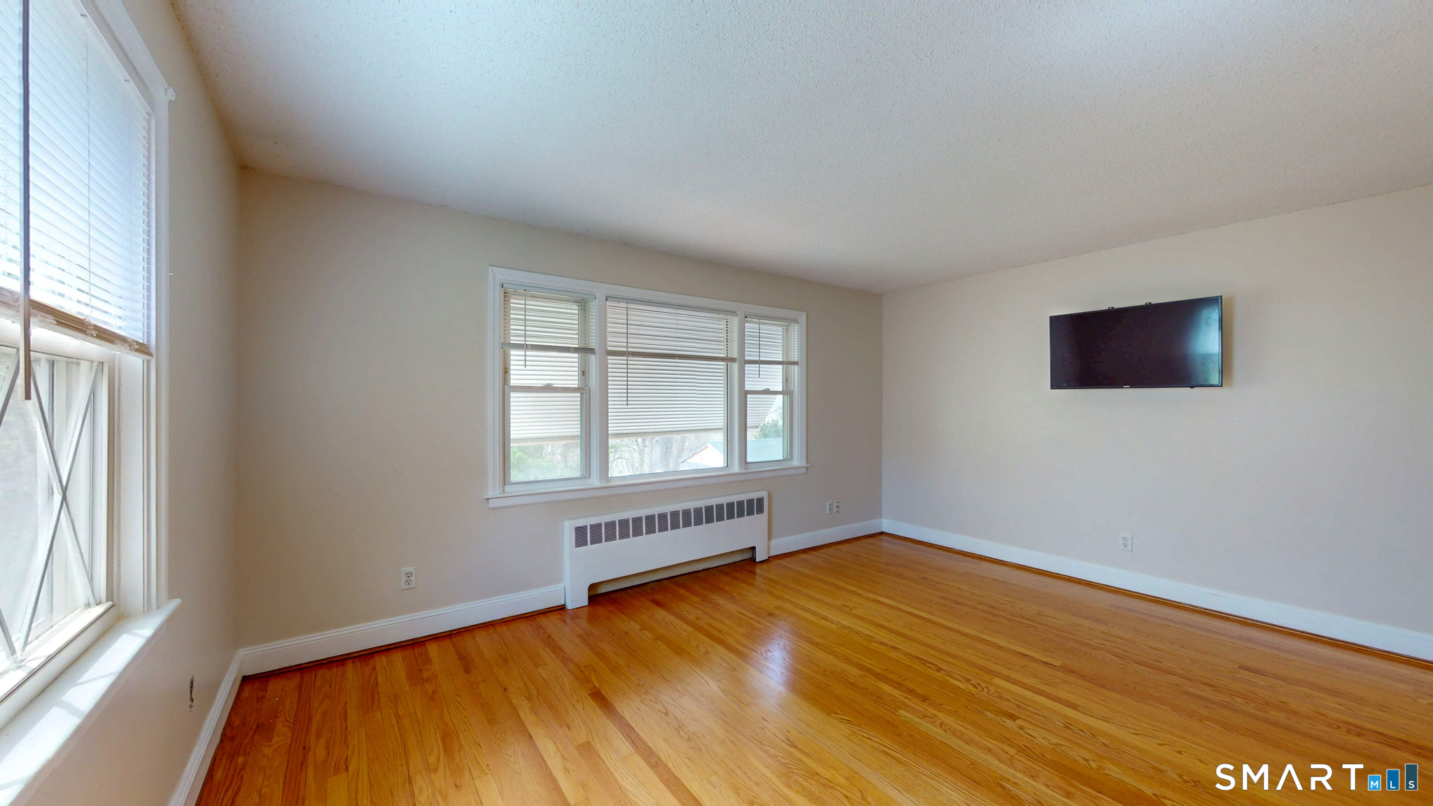 99 Sunset Ridge Drive East Hartford, CT 06118 - Photo 14 of 39 an empty room with wooden floor and windows