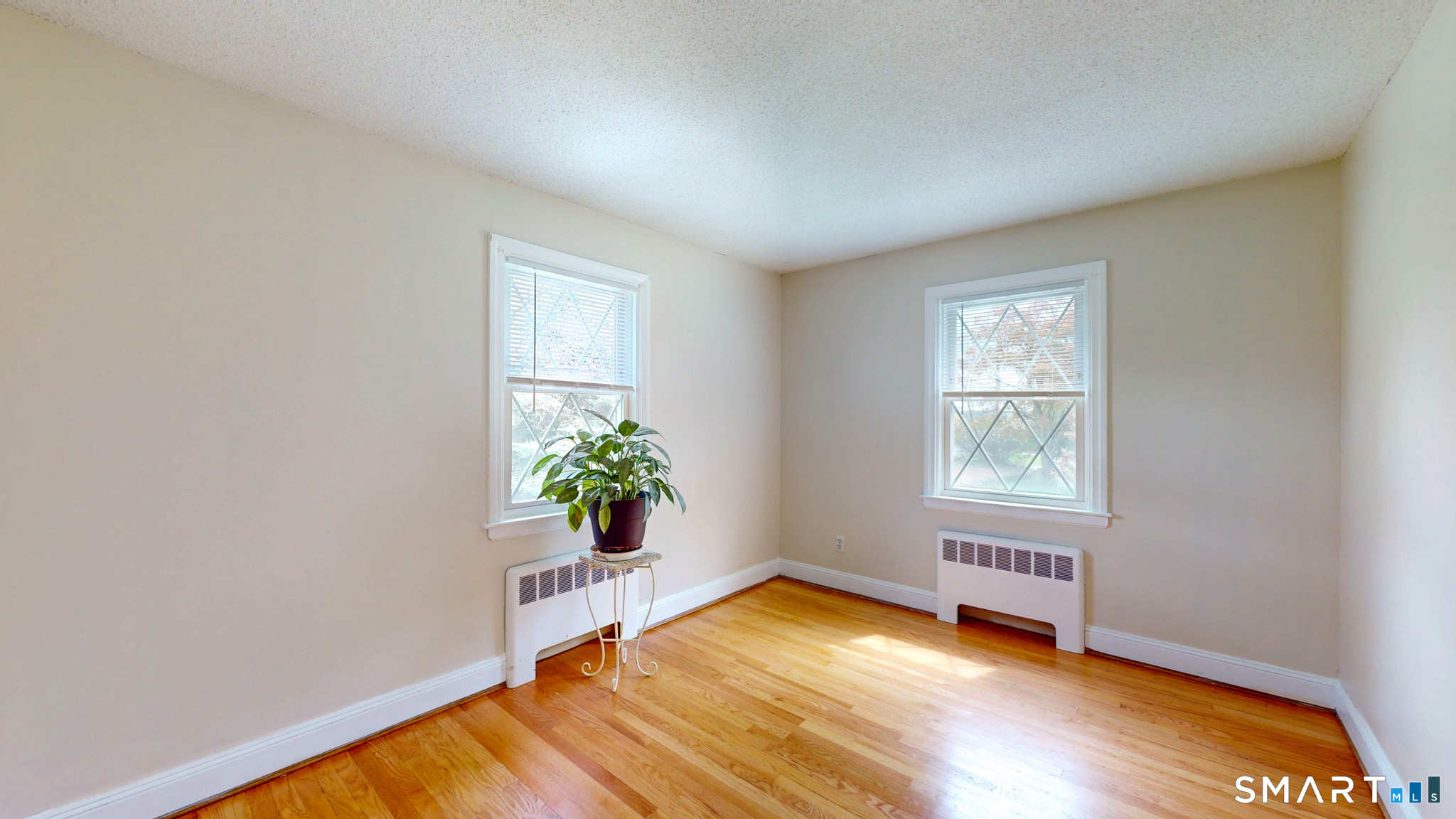 99 Sunset Ridge Drive East Hartford, CT 06118 - Photo 18 of 39 an empty room with wooden floor and windows