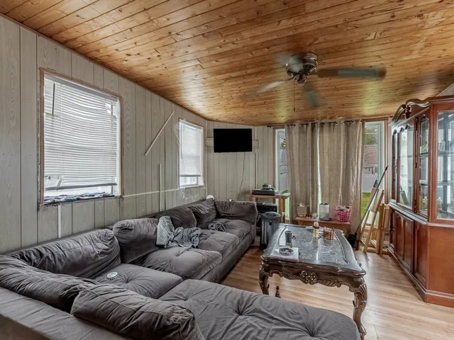 a living room with furniture a ceiling fan and a window