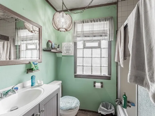 a bathroom with a sink a toilet and a mirror
