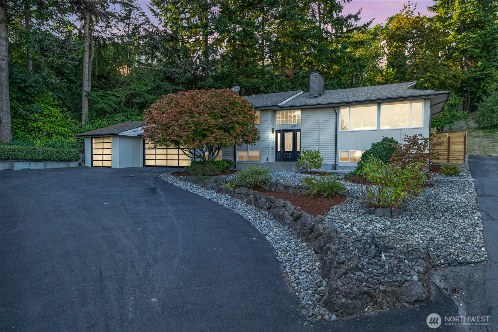 a view of a house with a yard and large tree