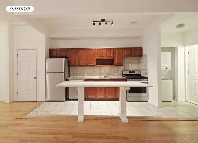 a kitchen with a refrigerator and a stove top oven