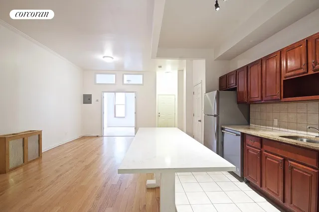 a large kitchen with cabinets wooden floor and stainless steel appliances