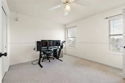 a view of a workspace with furniture and a window