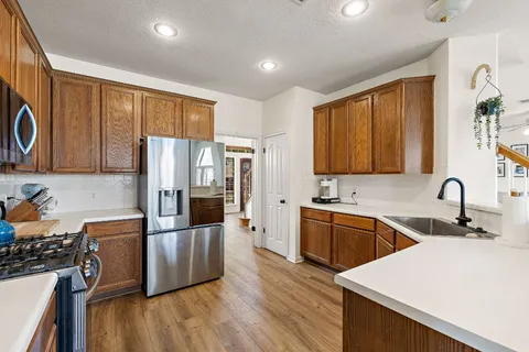 a kitchen with stainless steel appliances wooden floors and wooden cabinets
