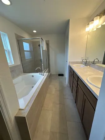 a bathroom with a tub sink and mirror