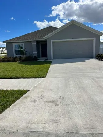 a front view of a house with a garden and yard