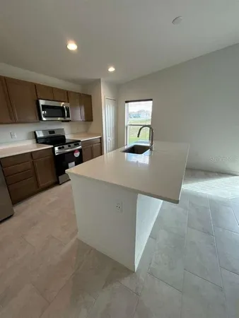 a kitchen with stainless steel appliances a refrigerator and a stove top oven