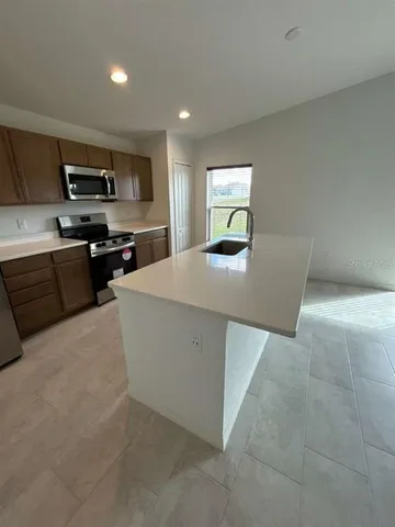 a kitchen with stainless steel appliances a refrigerator and a stove top oven