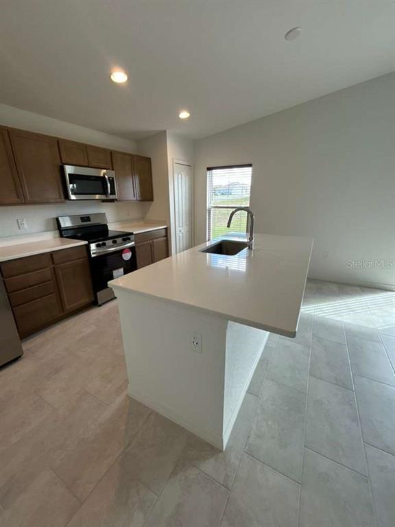 2203 Carson Loop Lake Lake Wales, FL 33859 - Photo 7 of 14 a kitchen with stainless steel appliances a refrigerator and a stove top oven
