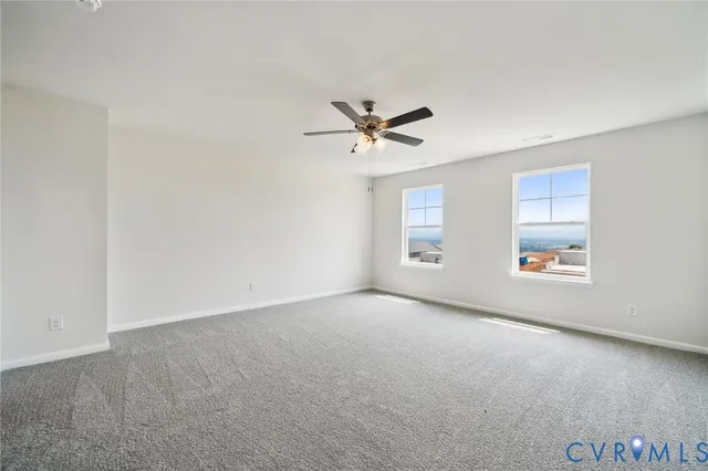 an empty room with windows and ceiling fan