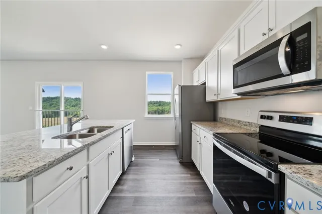 a kitchen with stainless steel appliances granite countertop a sink and a stove