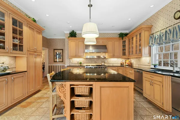 a kitchen with stainless steel appliances granite countertop a sink a stove and a refrigerator