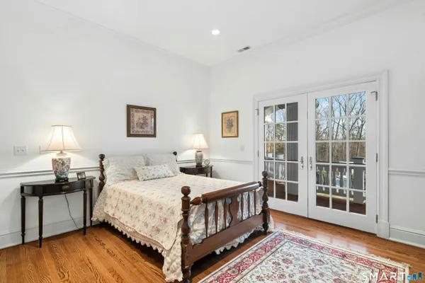 a bedroom with a bed a fireplace and a large window with outer view