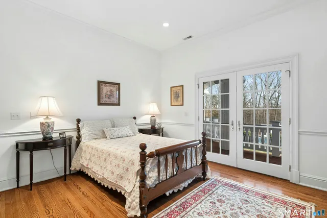 a bedroom with a bed a fireplace and a large window with outer view