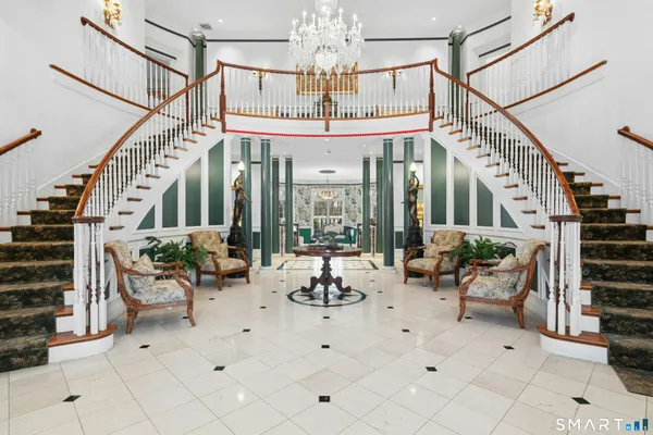 a living room with patio furniture and a chandelier