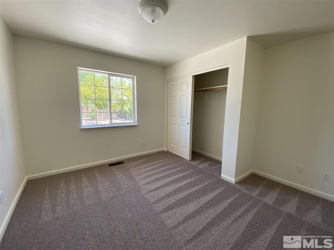 1200 Lattin Road Fallon, NV 89406 - Photo 9 of 19 an empty room with wooden floor and windows