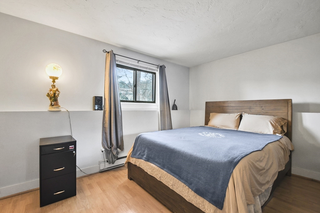 976 Plain Street, Unit 48 Marshfield, MA 02050 - Photo 16 of 20 a bedroom with a bed and a lamp