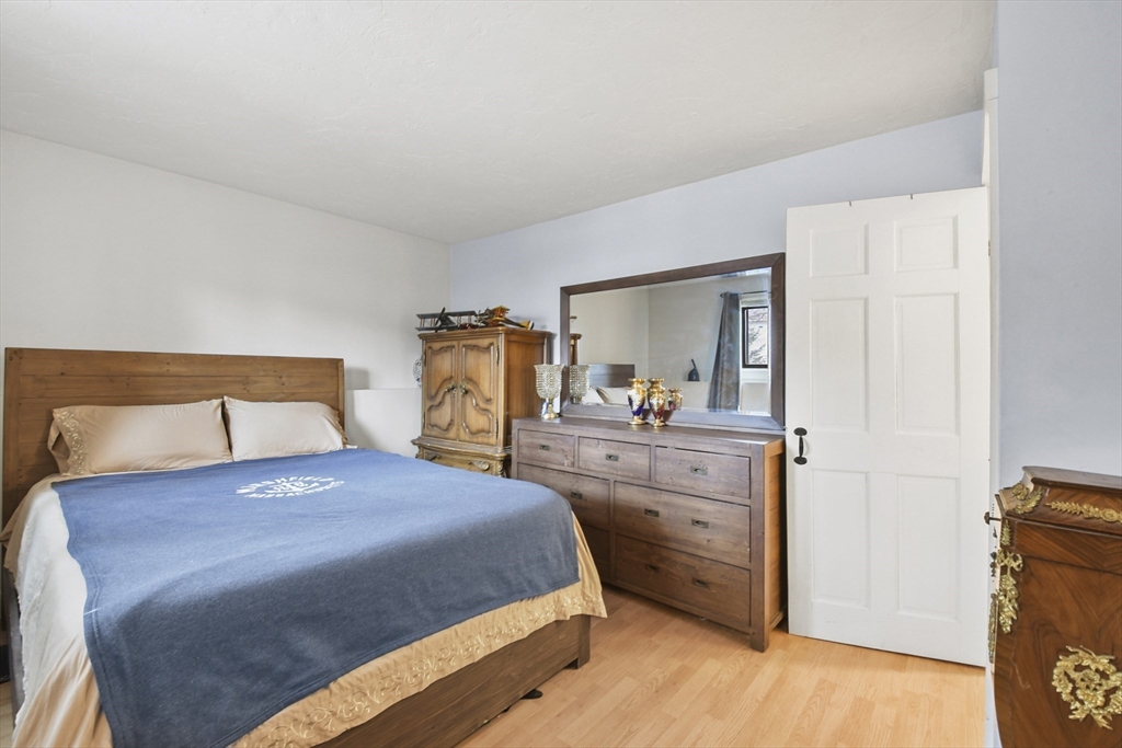 976 Plain Street, Unit 48 Marshfield, MA 02050 - Photo 17 of 20 a bedroom with a bed and a mirror on dresser