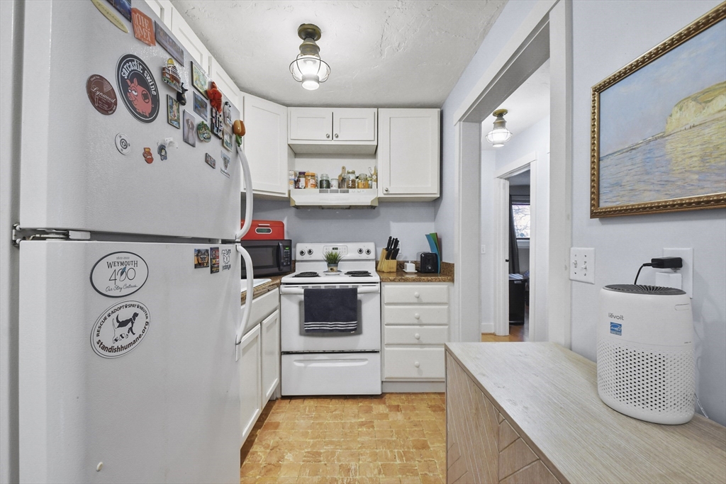 976 Plain Street, Unit 48 Marshfield, MA 02050 - Photo 6 of 20 a kitchen with a refrigerator and white stove top oven