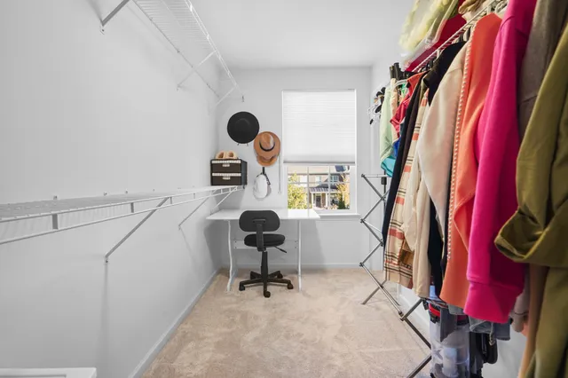 a view of walk in closet with clothes and shoes