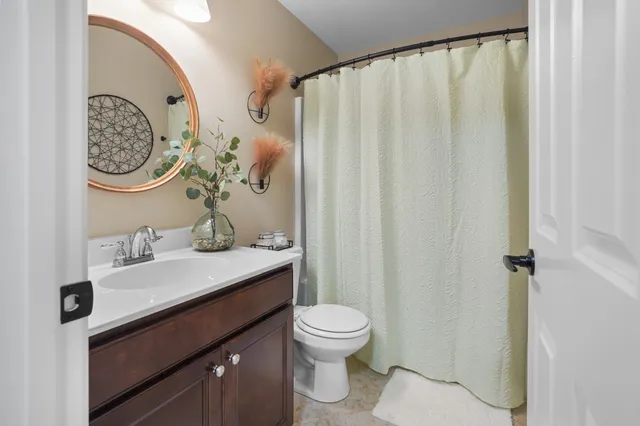 a bathroom with a sink vanity mirror and toilet
