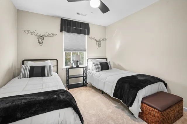 a bedroom with a large bed and a ceiling fan