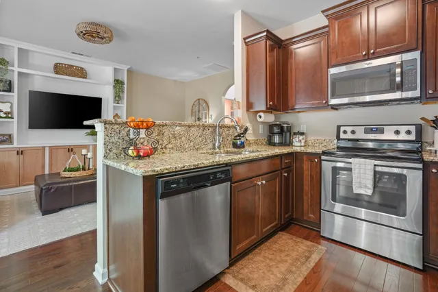 a kitchen with stainless steel appliances granite countertop a sink stove and microwave