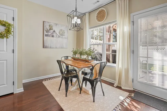 a dining room with furniture a chandelier and wooden floor