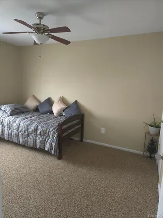 a bedroom with bed and ceiling fan