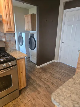 a kitchen with granite countertop a stove a sink and a microwave