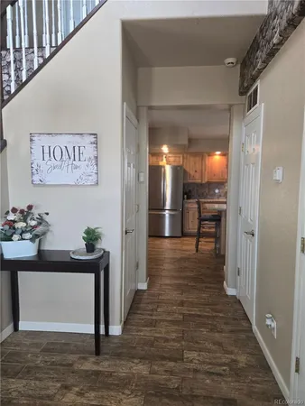 a view of a hallway with wooden floor and furniture