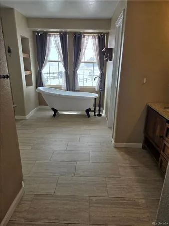 a view of an empty room with a fireplace and a window