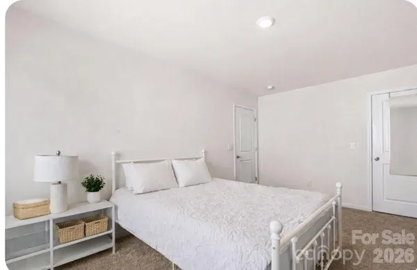 a bedroom with a bed and a night stand