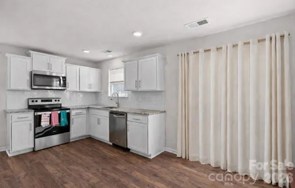 a kitchen with stainless steel appliances granite countertop a refrigerator and a stove top oven