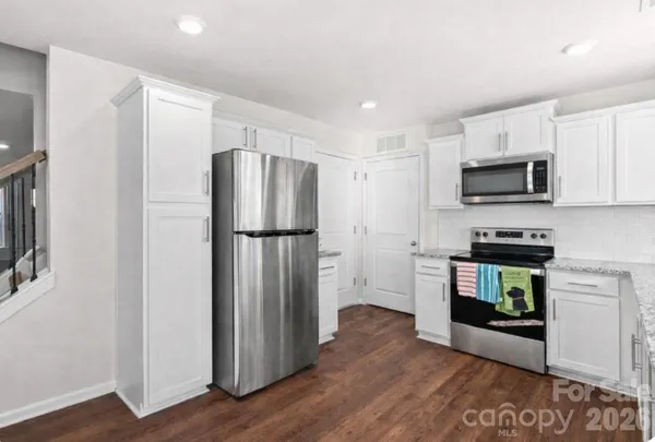 a kitchen with a refrigerator stove and wooden cabinets