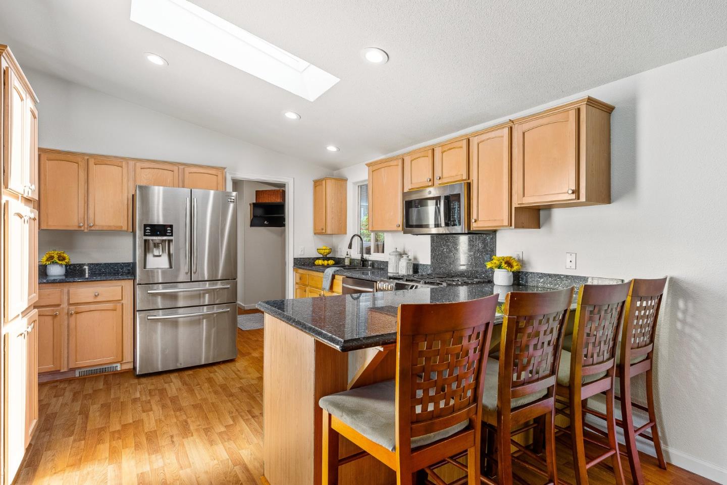 2155 Wharf Road, Unit 9 Capitola, CA 95010 - Photo 12 of 27 a kitchen with stainless steel appliances granite countertop a refrigerator a stove top oven a sink dishwasher and wooden cabinets with wooden floor