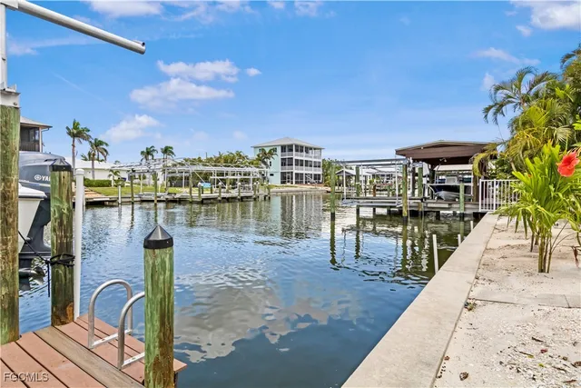 a kitchen with stainless steel appliances kitchen island granite countertop a table chairs stove and refrigerator