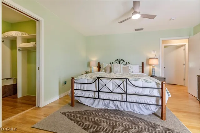 a spacious bedroom with a bed and a flat screen tv